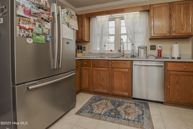 kitchen with brown cabinetry, ornamental molding, stainless steel appliances, and light tile patterned flooring