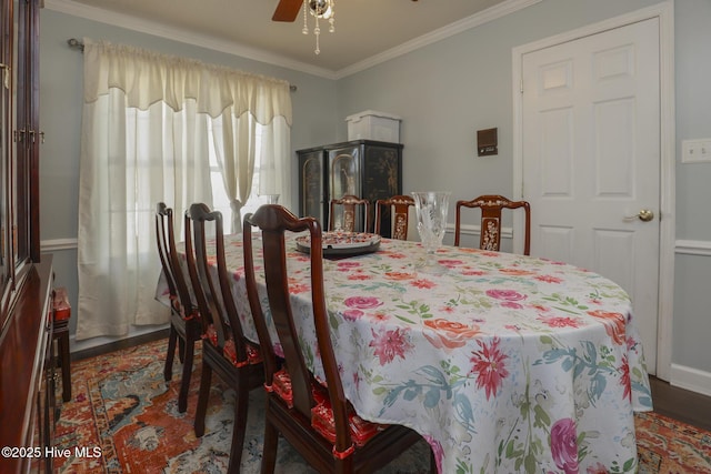 dining space featuring a ceiling fan, crown molding, and wood finished floors