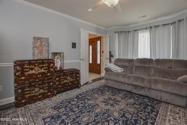 living room with visible vents, ornamental molding, ceiling fan, and a textured ceiling