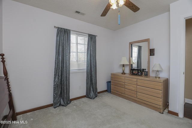 bedroom with baseboards, visible vents, a textured ceiling, and light colored carpet