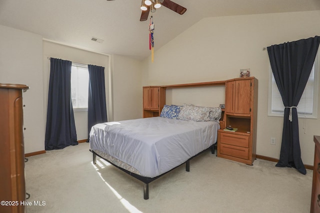 bedroom with lofted ceiling, light colored carpet, visible vents, and baseboards