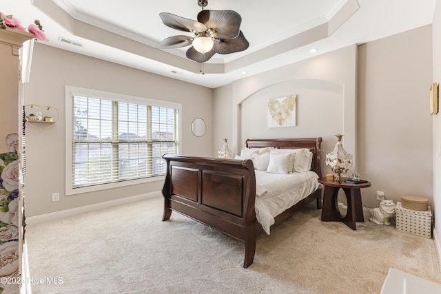 bedroom featuring crown molding, a raised ceiling, visible vents, light carpet, and baseboards