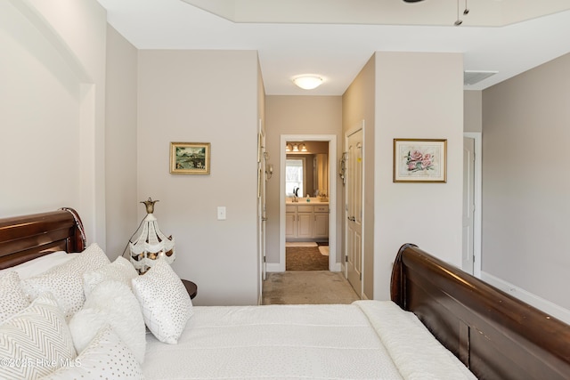 bedroom featuring light carpet and ensuite bathroom