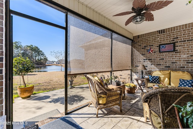 unfurnished sunroom with a water view and a ceiling fan