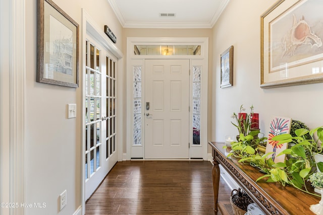 entryway with visible vents, dark wood finished floors, and ornamental molding