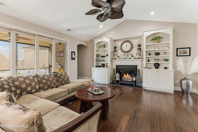 living area with visible vents, arched walkways, dark wood finished floors, a glass covered fireplace, and lofted ceiling