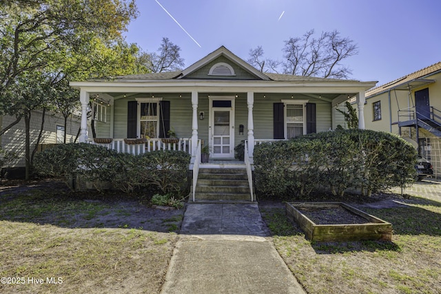 bungalow-style home with a vegetable garden and a porch