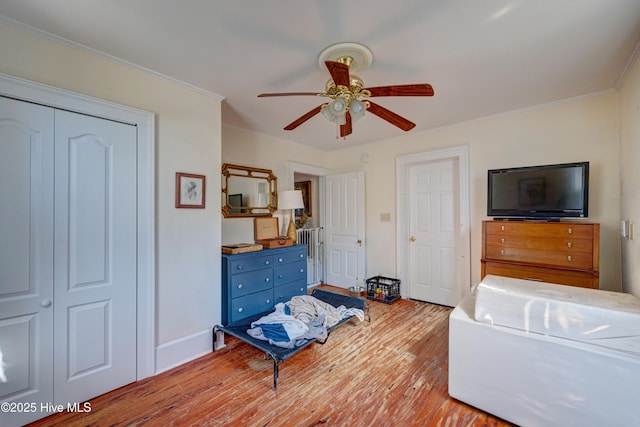 bedroom featuring baseboards, a ceiling fan, crown molding, and wood finished floors