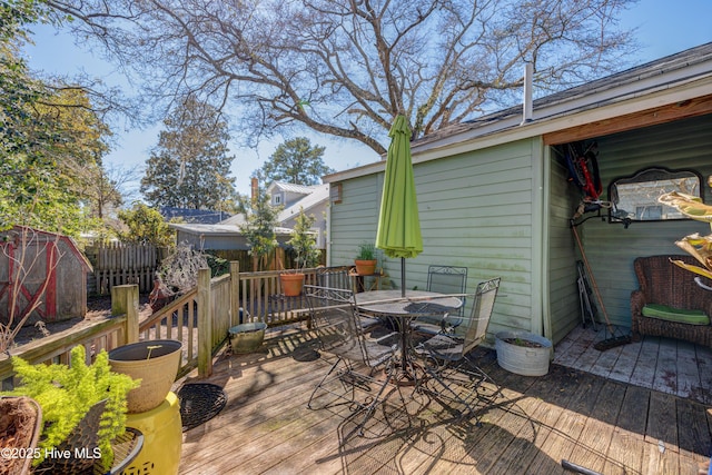 wooden terrace featuring outdoor dining area and fence