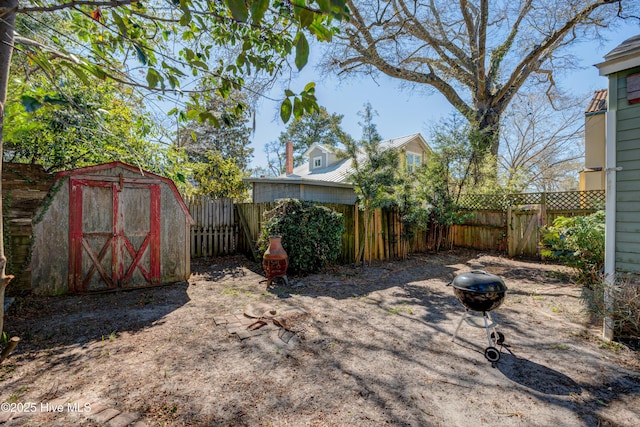 view of yard featuring a fenced backyard, a storage unit, and an outdoor structure