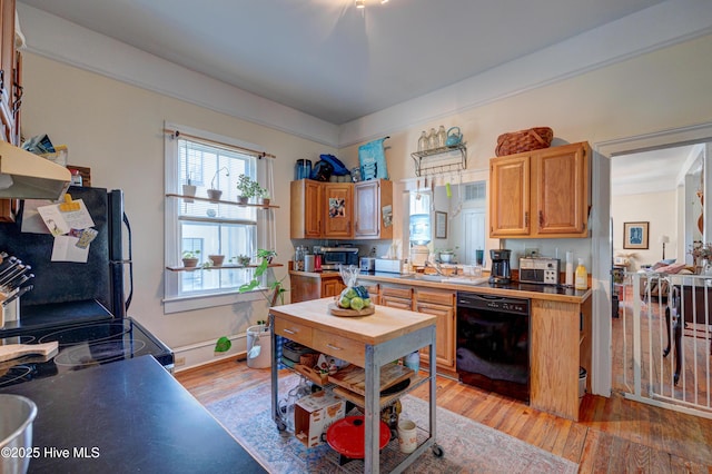 kitchen with black appliances, light wood finished floors, and light countertops