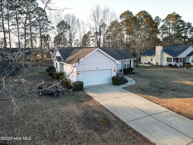 view of front facade featuring a garage, concrete driveway, and a front yard