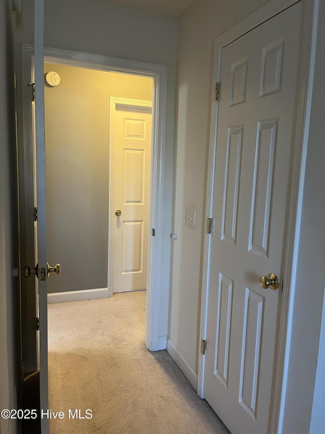 corridor with carpet flooring and baseboards