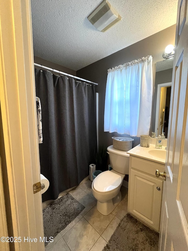 full bathroom with a textured ceiling, tile patterned flooring, toilet, vanity, and visible vents