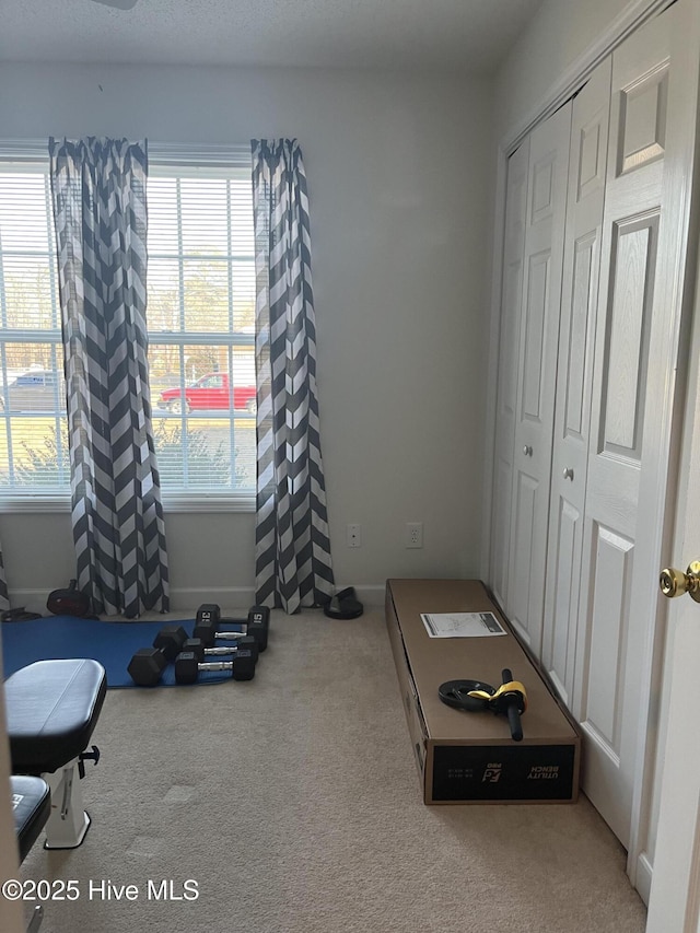 exercise room featuring carpet floors and baseboards