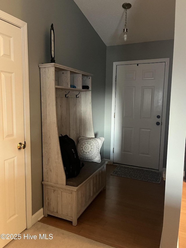 mudroom featuring lofted ceiling, light wood-style flooring, and baseboards