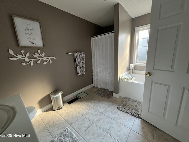 bathroom featuring baseboards, toilet, a garden tub, tile patterned flooring, and curtained shower