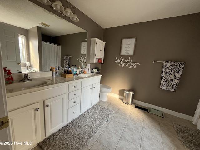 bathroom with toilet, tile patterned flooring, visible vents, and a sink