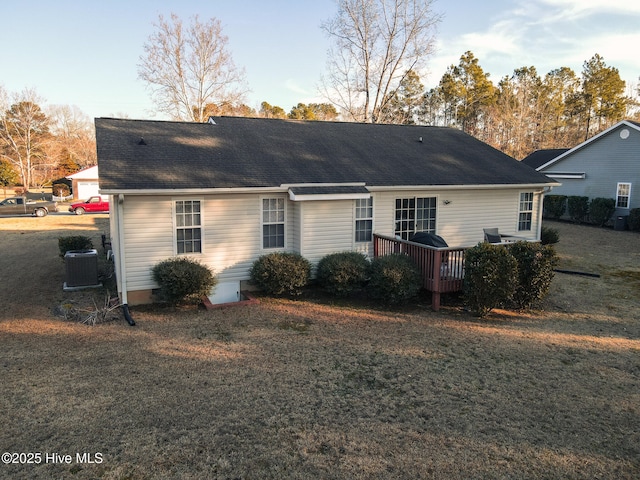 back of property with a deck, a shingled roof, a lawn, and central air condition unit