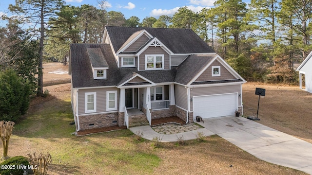 view of front of house featuring a shingled roof, driveway, stone siding, crawl space, and a front lawn