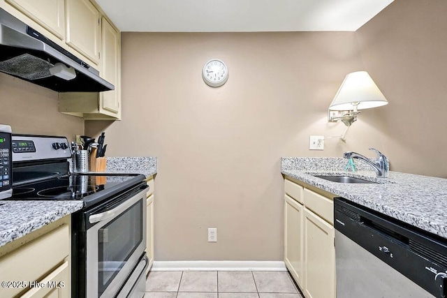 kitchen featuring stainless steel appliances, cream cabinets, light tile patterned flooring, a sink, and under cabinet range hood