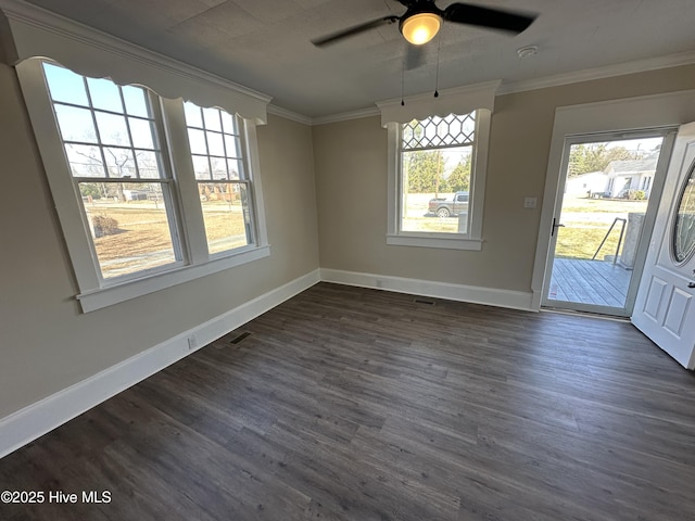 unfurnished dining area featuring ornamental molding, dark wood finished floors, and baseboards