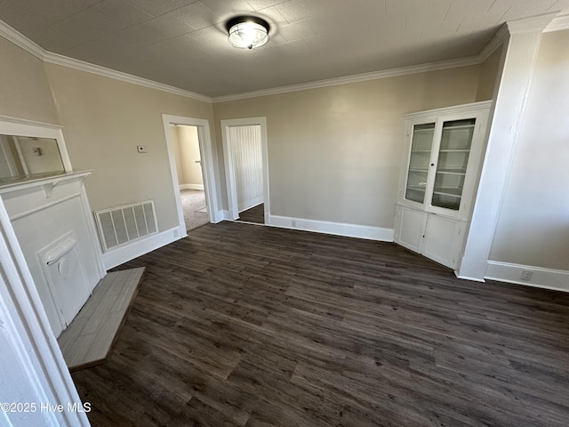 spare room featuring dark wood-style floors, visible vents, and crown molding