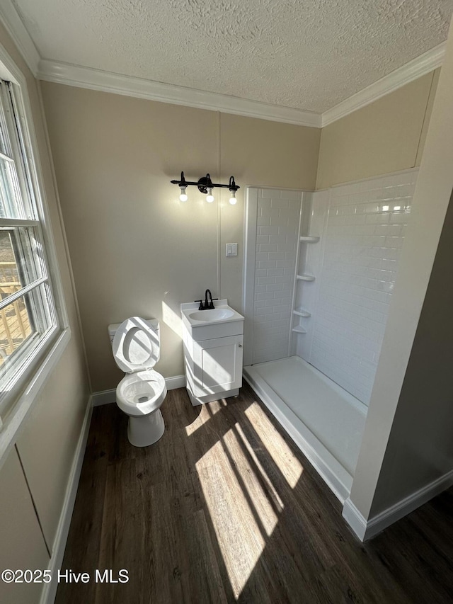 full bath with ornamental molding, wood finished floors, a textured ceiling, and walk in shower