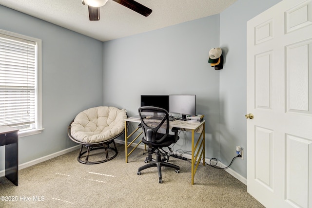 carpeted home office with a textured ceiling, a ceiling fan, and baseboards