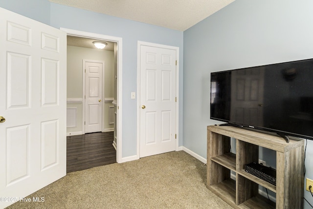 living area featuring a textured ceiling, baseboards, and carpet flooring