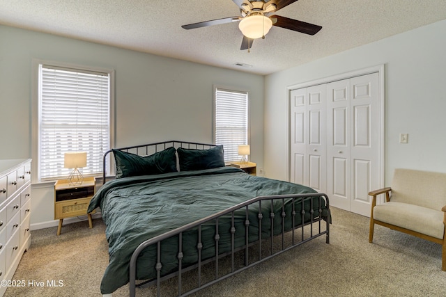 bedroom with multiple windows, visible vents, a closet, and light colored carpet