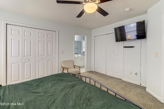 unfurnished bedroom with baseboards, carpet floors, a textured ceiling, and multiple closets