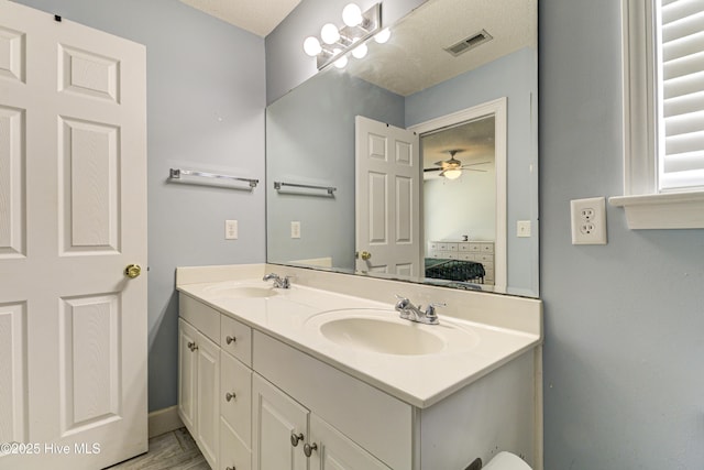 bathroom featuring connected bathroom, visible vents, a sink, and double vanity