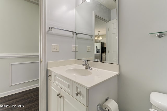 bathroom with vanity, toilet, and wood finished floors