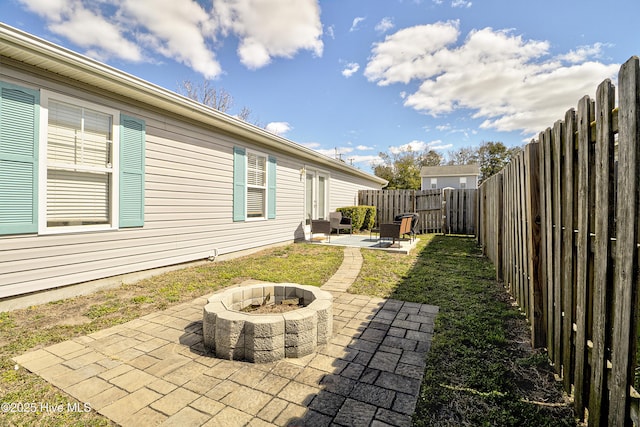 view of yard with a fire pit, a patio area, and a fenced backyard