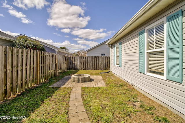 view of yard with a fenced backyard, a fire pit, and a patio