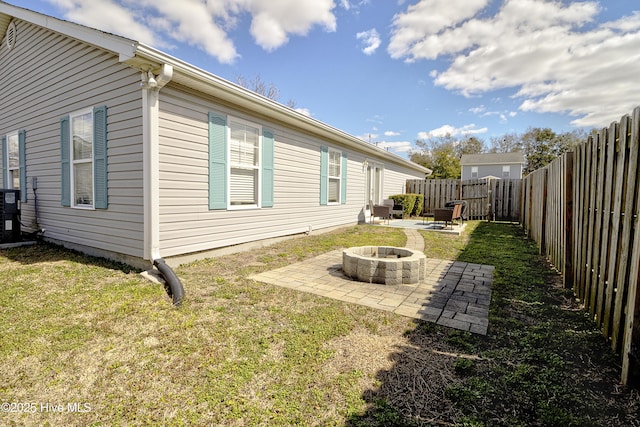 exterior space with a fire pit, a patio, a lawn, and a fenced backyard