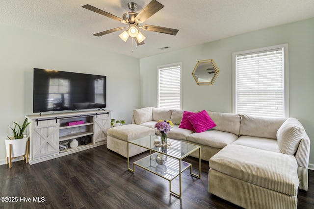 living room featuring a textured ceiling, ceiling fan, wood finished floors, and visible vents