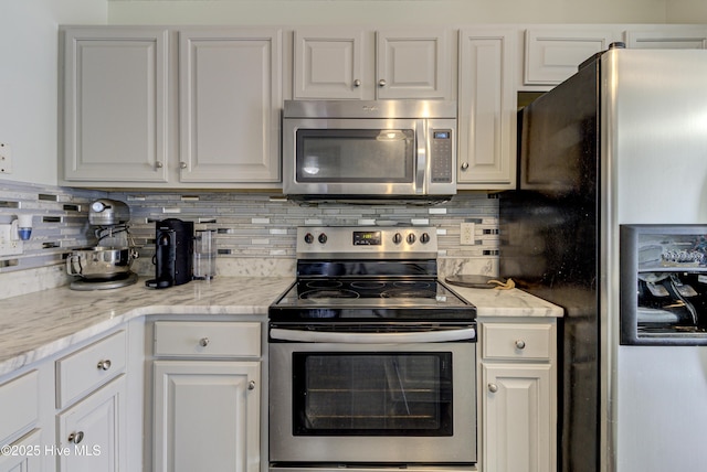 kitchen featuring stainless steel appliances, backsplash, and white cabinetry