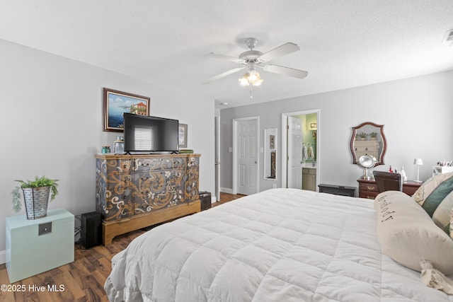 bedroom with ceiling fan, a textured ceiling, ensuite bathroom, wood finished floors, and visible vents