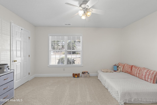 bedroom featuring baseboards, a ceiling fan, visible vents, and light colored carpet