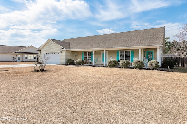 ranch-style house featuring an attached garage, fence, and a porch