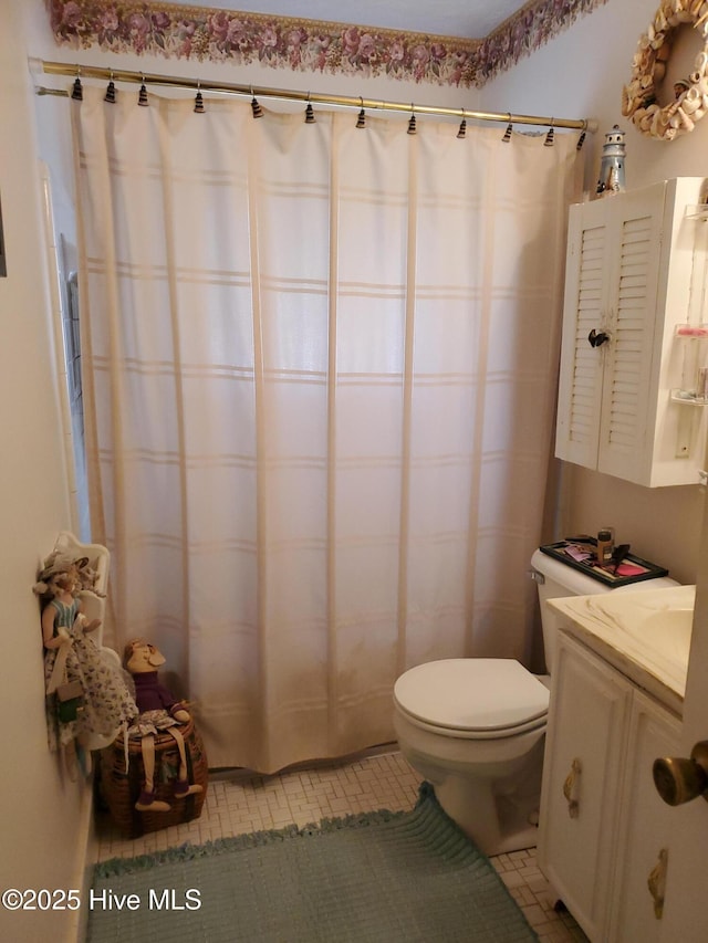 full bath featuring vanity, tile patterned flooring, and toilet