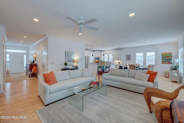 living room featuring light wood-style floors, recessed lighting, ornamental molding, and ceiling fan