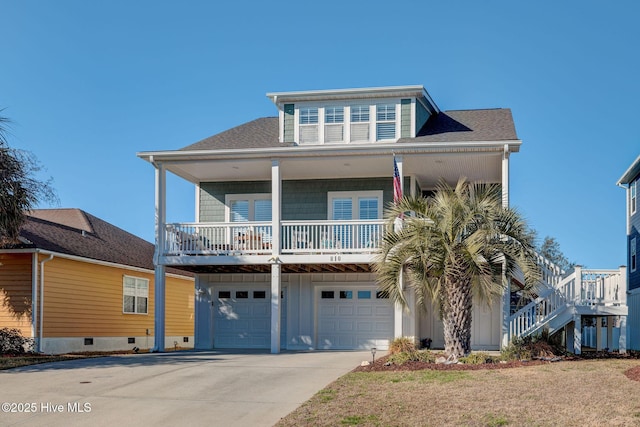 beach home featuring driveway, an attached garage, a porch, board and batten siding, and a front yard