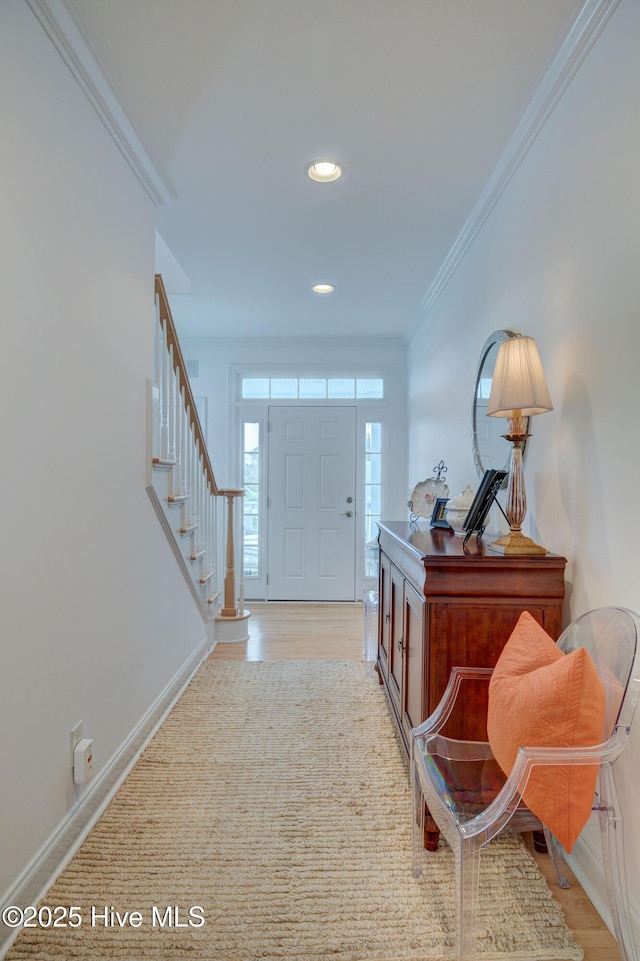 foyer featuring crown molding, stairway, recessed lighting, baseboards, and light wood finished floors