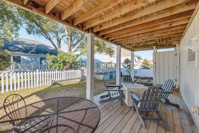 deck featuring outdoor dining area and a fenced backyard