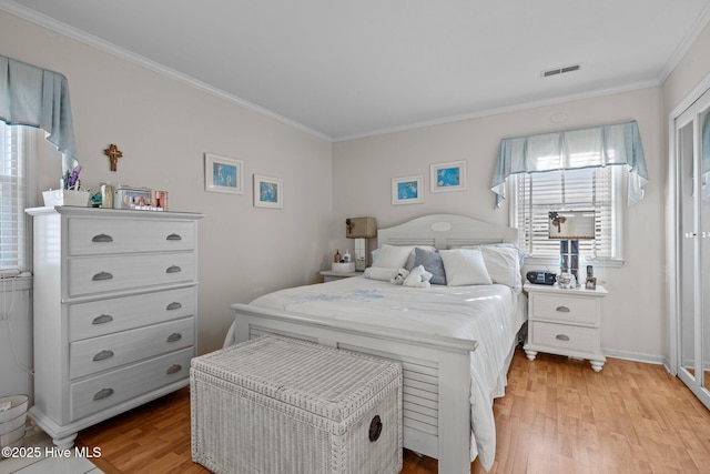 bedroom with light wood-type flooring, visible vents, and crown molding