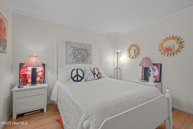 bedroom with baseboards, wood finished floors, and crown molding