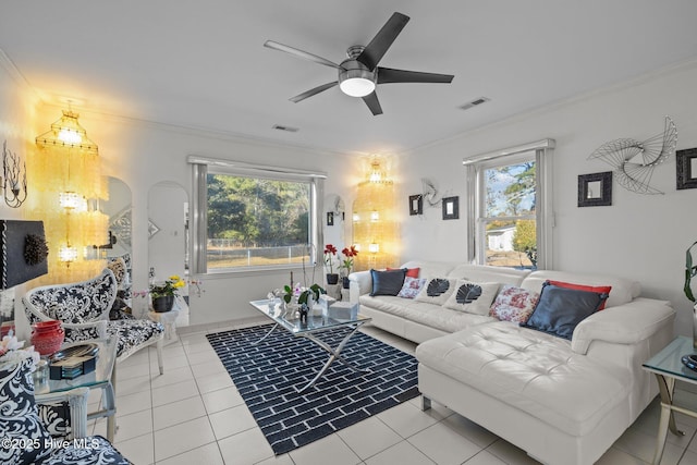 tiled living area featuring ornamental molding, plenty of natural light, and visible vents